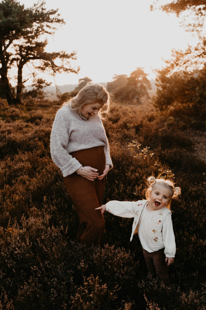 Motherhood shoot van zwangere moeder en peuter, vastgelegd op een puur en liefdevol moment